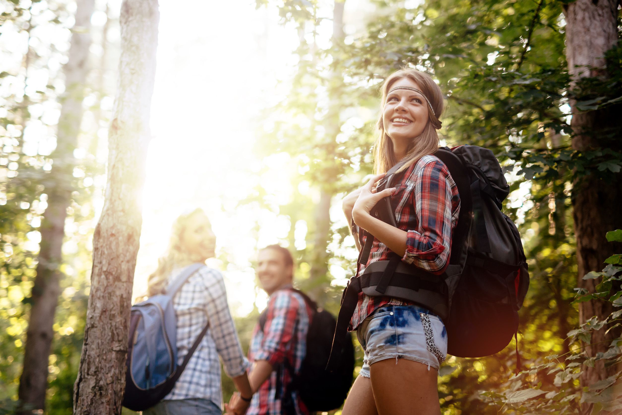 Smiling Hikers Walking Through Forest